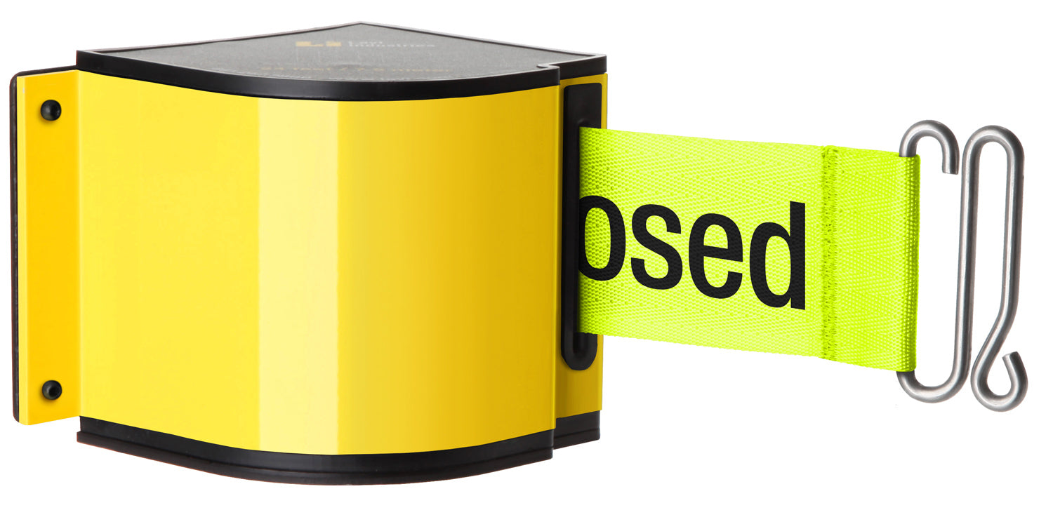 Retractable belt barrier with printed warning text mounted on warehouse upright