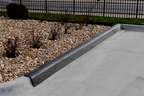 Black curb guard protector on parking lot curb