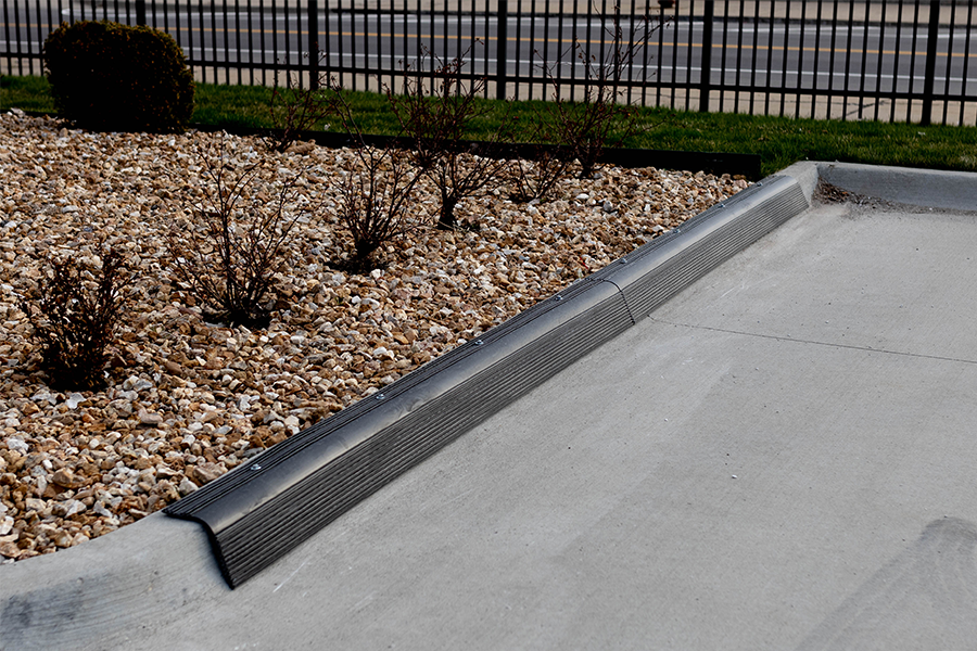 Black curb guard protector on parking lot curb