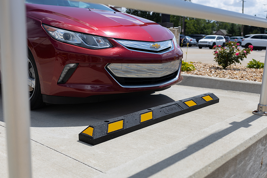 Rubber parking block with vehicle tire